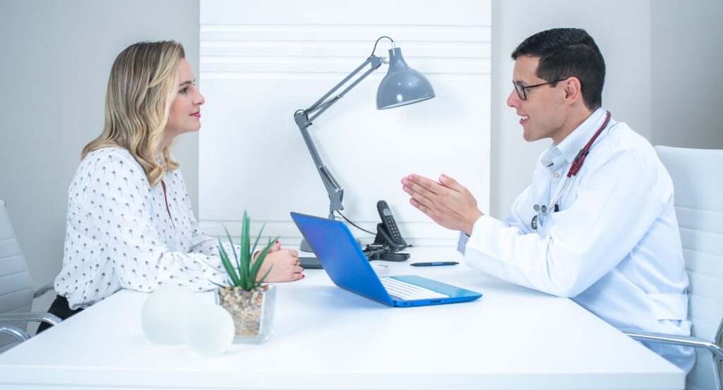 A doctor conducts a patient consultation in a bright, modern medical office.